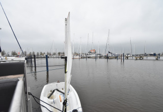 View from houseboat 'Boat' in the Netherlands showing a small docked boat and yachts in the marina.