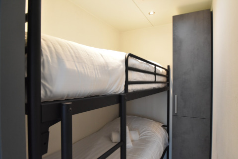 Room with bunk beds and wardrobe on the houseboat 'Boat' in the Netherlands, with white bedding.