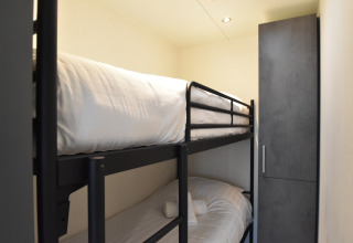 Room with bunk beds and wardrobe on the houseboat 'Boat' in the Netherlands, with white bedding.