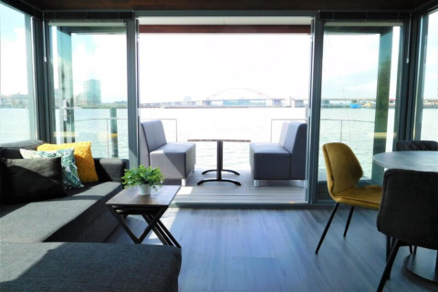 Living area aboard the houseboat ‘Boat’ in the Netherlands, featuring modern furniture and waterfront views.