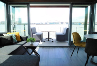Living area aboard the houseboat ‘Boat’ in the Netherlands, featuring modern furniture and waterfront views.