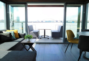 Living area aboard the houseboat ‘Boat’ in the Netherlands, featuring modern furniture and waterfront views.