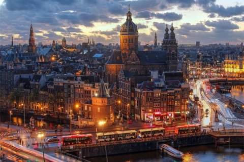 Evening view of Amsterdam’s canals, buses, and historic buildings, seen from the houseboat ‘Boat’.