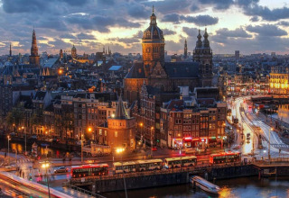 Evening view of Amsterdam’s canals, buses, and historic buildings, seen from the houseboat ‘Boat’.
