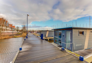 Casa flotante llamada Bermuda atracada en Volendam cerca del Fuerte Edam, Países Bajos, junto al muelle.