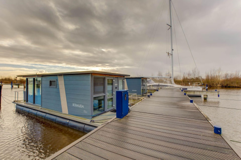 Flydende husbåd ved en mole, Houseboat i Volendam nær Fort Edam, Holland, under en overskyet himmel.