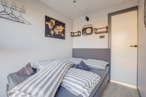 Dormitorio en una casa flotante en Volendam cerca de Fort Edam, con decoración gris y arte mural.