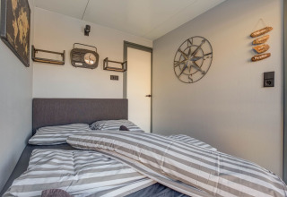 Camera da letto su una casa galleggiante a Volendam vicino a Fort Edam, con dettagli nautici e biancheria a righe.