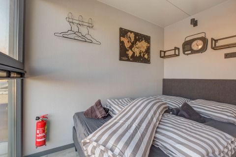 Schlafzimmer auf einem Hausboot in Volendam bei Fort Edam, mit gestreifter Bettwäsche und Dekor.