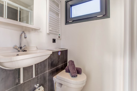 Moderne badkamer op een woonboot in Volendam met lavabok, toilet, handdoeken en raam bij Fort Edam.