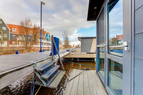 Blick von einem Hausboot in Volendam bei Fort Edam, Niederlande, mit bunten Häusern und Steg.