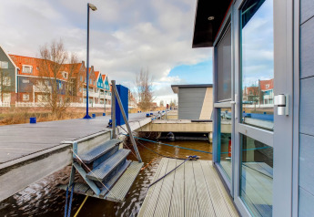 Vue d’une péniche à Volendam près du Fort Edam, Pays-Bas, avec quai et maisons colorées au bord de l’eau.