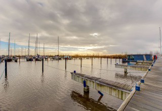 Casa flotante en un puerto deportivo cerca de Fort Edam en Volendam, Países Bajos, con cielo nublado.