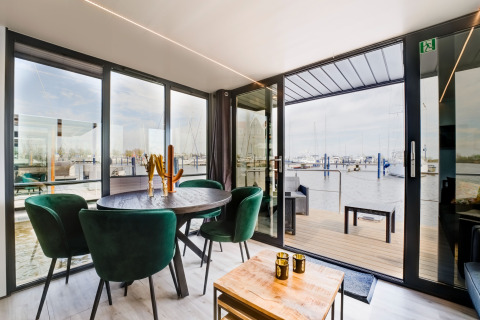 Soggiorno moderno sulla houseboat La Belle Vie nei Paesi Bassi con vista sul porto turistico.