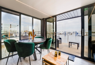 Soggiorno moderno sulla houseboat La Belle Vie nei Paesi Bassi con vista sul porto turistico.