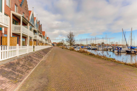 Vista di houseboat e porto turistico a Volendam vicino a Fort Edam, Paesi Bassi, con case tipiche.
