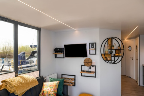 Soggiorno elegante sulla houseboat La Belle Vie nei Paesi Bassi, con arredi moderni e vista sul porto.