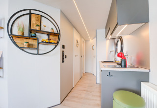 Cucina moderna e corridoio luminoso sulla casa galleggiante 'La Belle Vie' nei Paesi Bassi, arredo elegante.