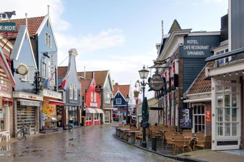 Strada caratteristica a Volendam, vicino a Fort Edam, Paesi Bassi, con case colorate e caffè all’aperto.