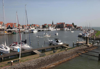 Udsigt over lystbådehavn i Volendam nær Fort Edam, Holland, med sejlbåde og farverige huse.