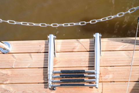 Scala pieghevole da bagno su un pontile di legno presso la houseboat «La Belle Vie» nei Paesi Bassi.