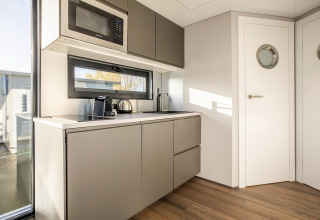 Moderne tekøkken ombord på husbåden Marina Sunrise i Holland, med mikrobølgeovn og kaffemaskine.