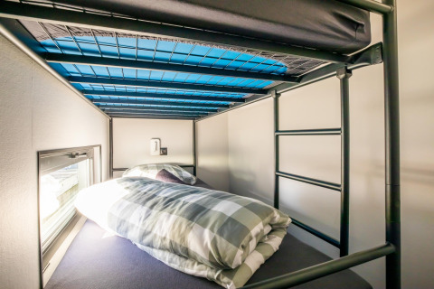 En hyggelig køjeseng med ternet sengetøj ombord på en husbåd ved navn 'Marina Sunrise' i Holland.