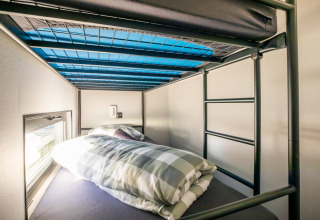En hyggelig køjeseng med ternet sengetøj ombord på en husbåd ved navn 'Marina Sunrise' i Holland.