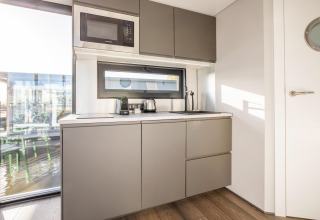 Moderne tekøkken ombord på husbåden 'Marina Sunrise' i Holland, med mikroovn og apparater.