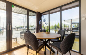 Coin repas avec vue sur le port de plaisance à bord d'une péniche à Volendam Marina, Pays-Bas, journée ensoleillée.
