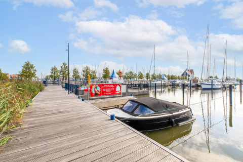 Foto der Houseboat «in Volendam Marina» mit Bootsstegen und Segelbooten in einem niederländischen Hafen.