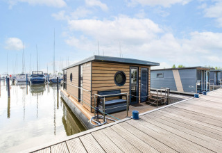 Hausboot in der Volendam Marina, Niederlande, festgemacht an einem Steg, umgeben von Yachten.