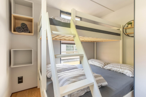 Litera moderna y estantes de pared en una habitación compacta de una casa flotante en Volendam Marina, Países Bajos.