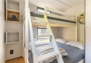 Modern stapelbed en wandplanken in een compacte kamer op een woonboot in Volendam Marina, Nederland.