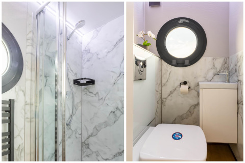 Salle de bain moderne et douche avec murs effet marbre sur une péniche à Volendam Marina, Pays-Bas.