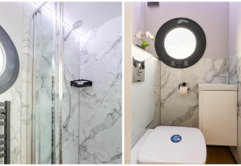 Salle de bain moderne et douche avec murs effet marbre sur une péniche à Volendam Marina, Pays-Bas.