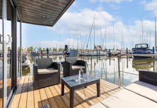 Terras van een woonboot in Volendam Marina, Nederland, met zicht op de jachthaven en boten.