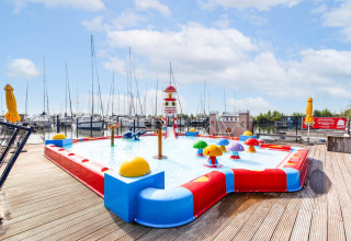 Kinderzwembad met kleurrijke speelelementen op een woonboot in Volendam Marina, Nederland.