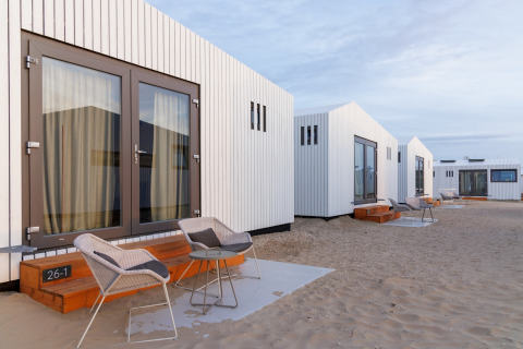 Moderne hytter på sandet strand ved Beach Houses Zandvoort 2, Zandvoort, Holland, ved solnedgang.