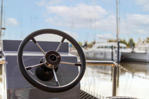 Stuur van een woonboot in Volendam Marina, Nederland, met zicht op water en boten op de achtergrond.