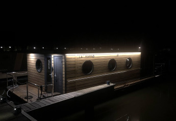 Une péniche nommée 'Wave' est éclairée la nuit à Volendam Marina, aux Pays-Bas.