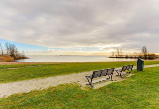 Bänke mit Blick auf den See bei Volendam Marina, Niederlande, an einem ruhigen Tag im Freien.
