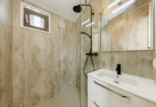 Moderne badeværelse med brusedør, spejl og vask på Beach Houses Zandvoort 2, Nederlandene.