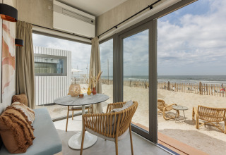 Lyst strandhusinteriør med havudsigt fra store vinduer, Zandvoort Beach Houses i Holland.