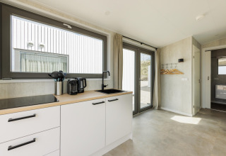 Lyst, moderne køkken og opholdsrum ved Beach Houses Zandvoort 3 i Holland med store vinduer og minimalisme.