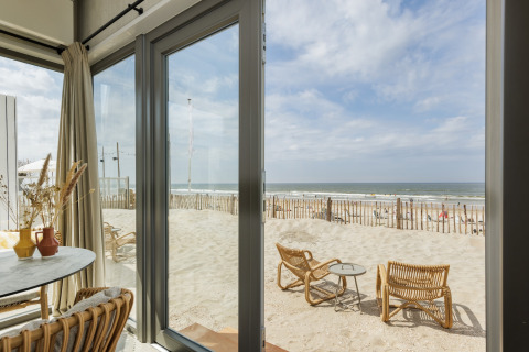 Udsigt fra Beach Houses Zandvoort 3 i Holland med terrasse, sand, hav og strandmøbler ved stranden.
