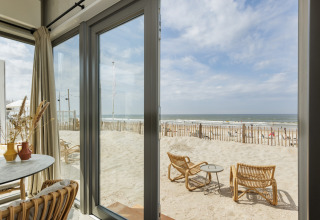 Udsigt fra Beach Houses Zandvoort 3 i Holland med terrasse, sand, hav og strandmøbler ved stranden.
