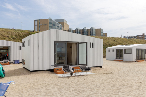 Strandhus ved Zandvoort med moderne hvide facader på sandet med hoteller i baggrunden, Holland.