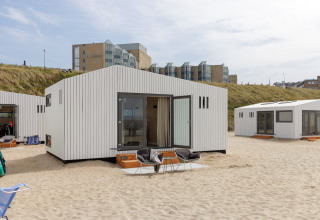 Strandhus ved Zandvoort med moderne hvide facader på sandet med hoteller i baggrunden, Holland.