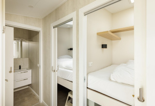 Et lyst og kompakt soveværelse og badeværelse i Beach Houses Zandvoort 3, Holland, med moderne indretning.
